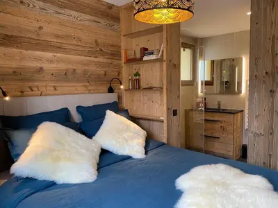 a bedroom with a blue bed with two white pillows at A place 2 be, Megève centre in Megève
