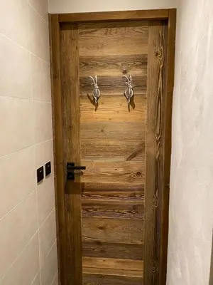 a bathroom with a wooden door in a room at A place 2 be, Megève centre in Megève