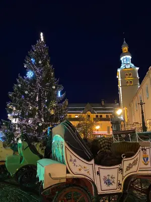 a christmas tree in front of a horse drawn carriage at A place 2 be, Megève centre in Megève