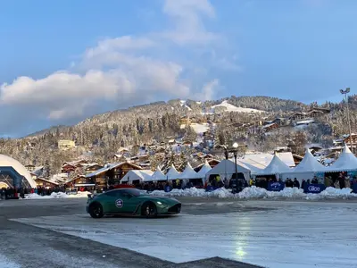 a green car driving down a street in front of a market at A place 2 be, Megève centre in Megève