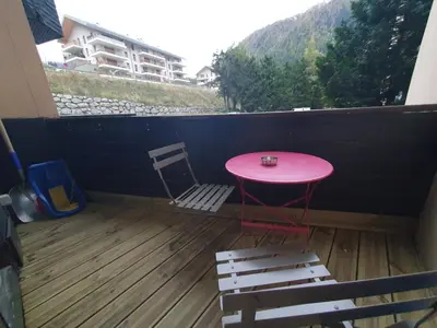 a pink table and a chair on a balcony at Chamonix / Argentière - Duplex 6p in Chamonix-Mont-Blanc