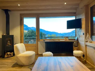 a living room with a table and a large window at CHALET 