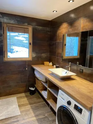 a bathroom with a washing machine and a sink at CHALET 