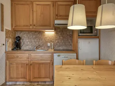 a kitchen with wooden cabinets and a wooden table at Appartement 2 pièces avec terrasse, animaux admis, proche pistes - Megève - FR-1-453-225 in Megève