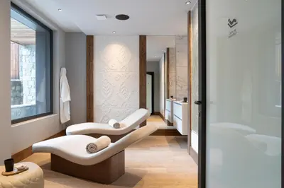 a bathroom with two white chairs and a tub at MGM Hôtels & Résidences - Résidence Chalets Laska in Les Contamines-Montjoie