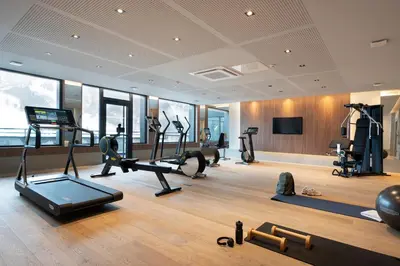 a gym with treadmills and exercise equipment in a building at MGM Hôtels & Résidences - Résidence Chalets Laska in Les Contamines-Montjoie