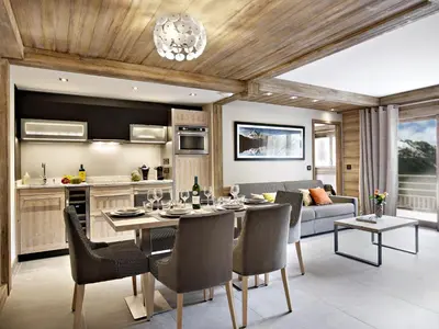 a kitchen and living room with a table and chairs at MGM Hôtels & Résidences - Résidence Chalets Laska in Les Contamines-Montjoie