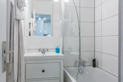 a white bathroom with a sink and a shower at Apartment Mont du Soleil - Central Chamonix Mont Blanc in Chamonix-Mont-Blanc