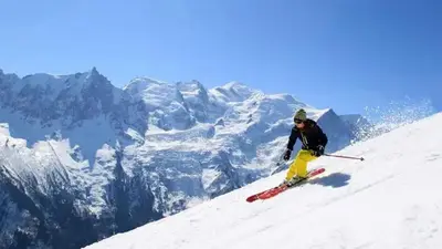 a man is skiing down a snow covered mountain at Apartment Mont du Soleil - Central Chamonix Mont Blanc in Chamonix-Mont-Blanc