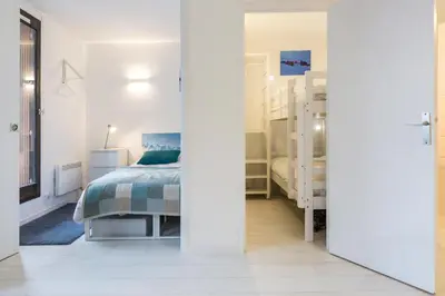 a white bedroom with a bed and a window at Apartment Mont du Soleil - Central Chamonix Mont Blanc in Chamonix-Mont-Blanc