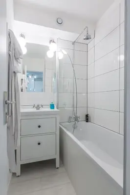 a white bathroom with a tub and a sink at Apartment Mont du Soleil - Central Chamonix Mont Blanc in Chamonix-Mont-Blanc