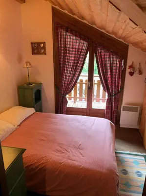 a bedroom with a large bed and a window at Bel appartement au décor Montagnard - 80m2 in Les Contamines-Montjoie