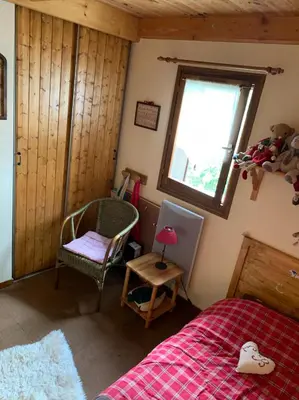 a bedroom with a bed and a window and a chair at Bel appartement au décor Montagnard - 80m2 in Les Contamines-Montjoie