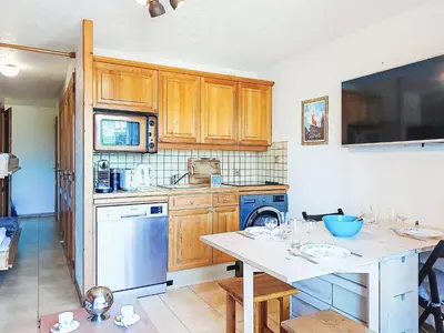 a washing machine in a kitchen with wooden cabinets at Apartment Pointe des aravis B13 by Interhome in Saint-Gervais-les-Bains