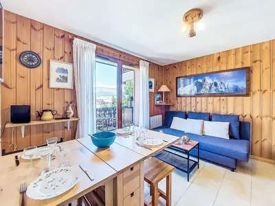 a living room with a blue couch and a table at Apartment Pointe des aravis B13 by Interhome in Saint-Gervais-les-Bains