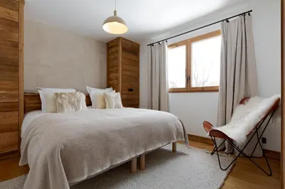 a bedroom with a large bed and a window at Le Refuge des Anges in Megève