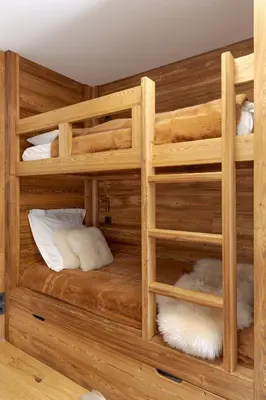 two bunk beds in a room with wooden walls at Le Refuge des Anges in Megève