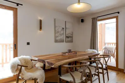 a dining room with a wooden table and chairs at Le Refuge des Anges in Megève