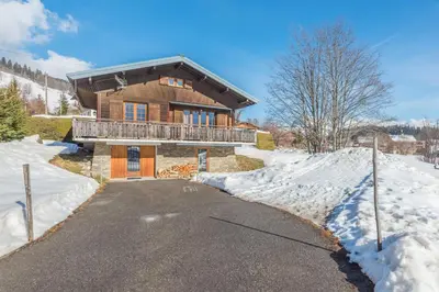 a house in the snow with a driveway at Le Chalet des Neiges - Welkeys in Megève