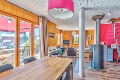 a living room with a wooden table and chairs at Le Chalet des Neiges - Welkeys in Megève