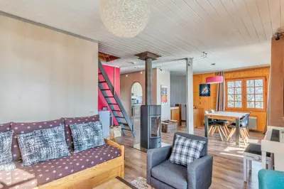 a living room with a couch and a table at Le Chalet des Neiges - Welkeys in Megève