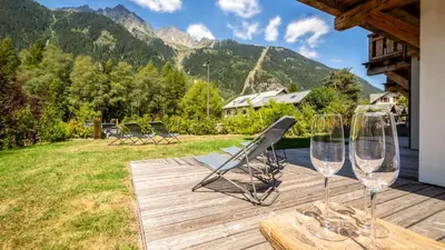 two wine glasses sitting on a table on a deck at Appartement Green in Chamonix-Mont-Blanc