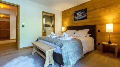 a bedroom with a bed with a bench next to it at Appartement Green in Chamonix-Mont-Blanc
