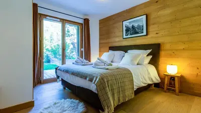 a bedroom with a bed with a wooden wall at Appartement Green in Chamonix-Mont-Blanc