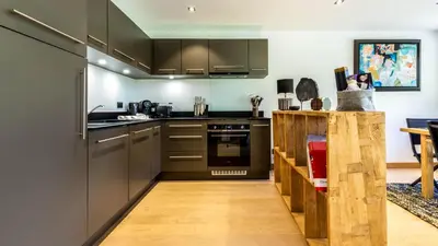 a kitchen with stainless steel appliances and a wooden floor at Appartement Green in Chamonix-Mont-Blanc