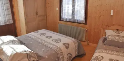 a bedroom with two beds and a window at Le clair logis in Sixt