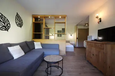 a living room with a blue couch and a tv at Résidence Prarion 1 - Prarion 2 MAE-4874 in Les Houches