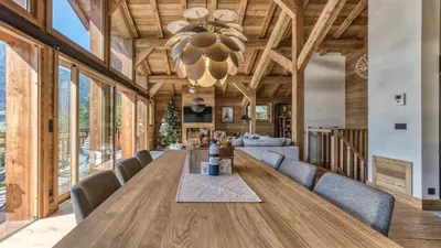 a dining room with a large wooden table and chairs at Chalet Hupa in Les Houches