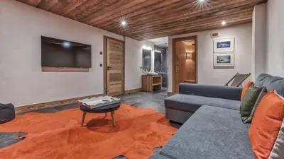 a living room with a couch and a tv at Chalet Hupa in Les Houches