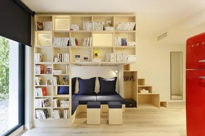 a room with a library with a chair and bookshelves at Appart'hôtel Bellamy Chamonix in Chamonix-Mont-Blanc