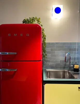 a red refrigerator in a kitchen next to a sink at Appart'hôtel Bellamy Chamonix in Chamonix-Mont-Blanc