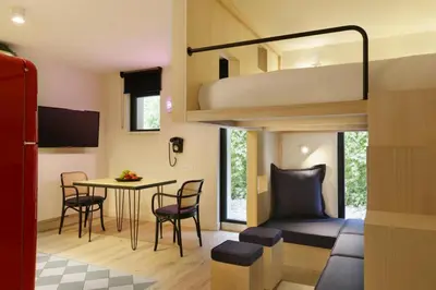 a small room with a bunk bed and a table and chairs at Appart'hôtel Bellamy Chamonix in Chamonix-Mont-Blanc