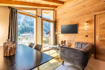 a dining room with a table and chairs and a television at Sapelli apartment Argentière Chamonix - by EMERALD STAY in Chamonix-Mont-Blanc