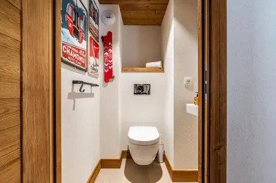 a small bathroom with a toilet and some pictures on the wall at Sapelli apartment Argentière Chamonix - by EMERALD STAY in Chamonix-Mont-Blanc