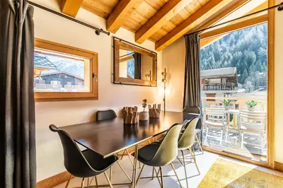 a dining room with a table and chairs and a large window at Sapelli apartment Argentière Chamonix - by EMERALD STAY in Chamonix-Mont-Blanc