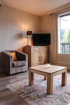 a living room with a coffee table and a television at Appartement Lyret centre Chamonix, Vue d'exception in Chamonix-Mont-Blanc