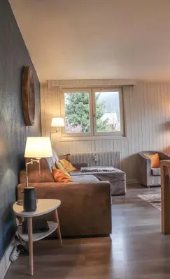 a living room with a couch and a table at Appartement Lyret centre Chamonix, Vue d'exception in Chamonix-Mont-Blanc