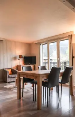 a dining room with a wooden table and chairs at Appartement Lyret centre Chamonix, Vue d'exception in Chamonix-Mont-Blanc