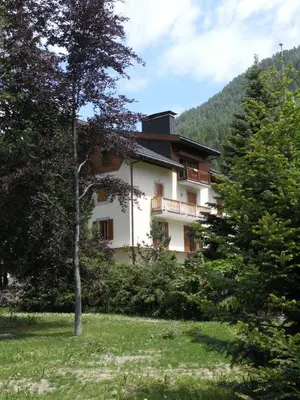 a building in the middle of a field with trees at Appartement Arolles in Chamonix-Mont-Blanc