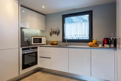 a kitchen with white cabinets and a window at La Cordee 124 Apartment - Chamonix All Year in Chamonix-Mont-Blanc