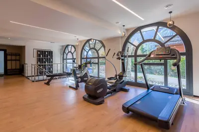 a gym with treadmills and ellipticals in a room with windows at La Cordee 124 Apartment - Chamonix All Year in Chamonix-Mont-Blanc