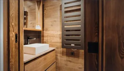 a bathroom with a white sink and a wooden door at Interlude Megeve in Megève