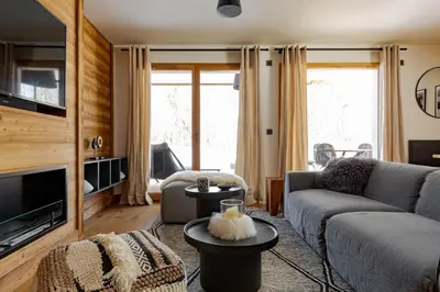 a living room with a couch and a tv at Interlude Megeve in Megève