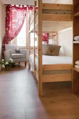 a bedroom with two bunk beds and a chair at Appartement Le Lutetia in Chamonix-Mont-Blanc