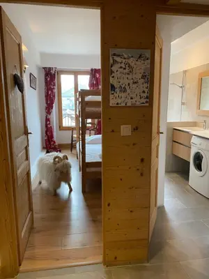 a dog walking into a room with a bedroom at Appartement Le Lutetia in Chamonix-Mont-Blanc