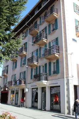 a white building with balconies on a street at Appartement Le Lutetia in Chamonix-Mont-Blanc